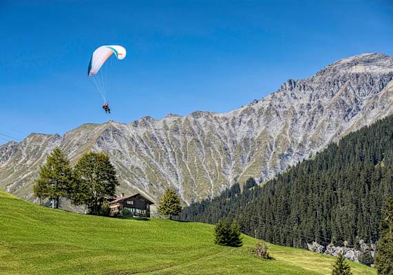 Die Tandempiloten vor wunderschönem, sonnigen Bergpanorama.