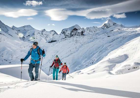 Der Bergführer leitet die Skitourengruppe durchs freie Gelände