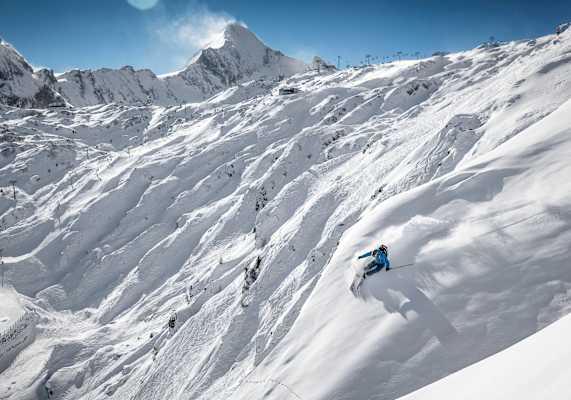 Ein Freerider im freien Gelände, im Hintergrund das Kitzsteinhorn