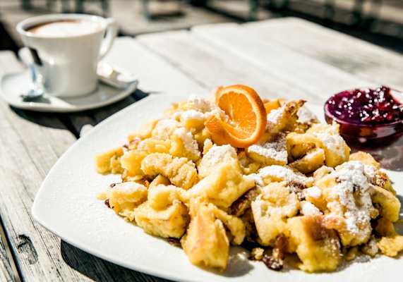 Der Kaiserschmarrn serviert mit einer Tasse Kaffee