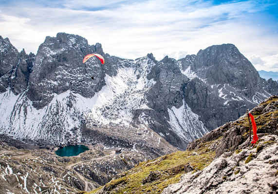 Die Tandemflieger blicken von oben auf den Bergsee