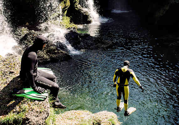 Ein Schnorchler springt beim Traunfall ins Wasser.