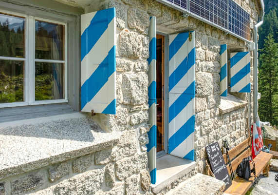 Die Treschhütte hat typische blau-weiß gestreifte Fensterläden.