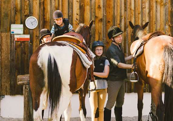 Kinder steigen auf ihr Pferd auf