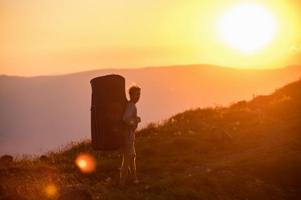 Ein Kletterer und seine Bouldermatte im Sonnenuntergang auf der Koralpe