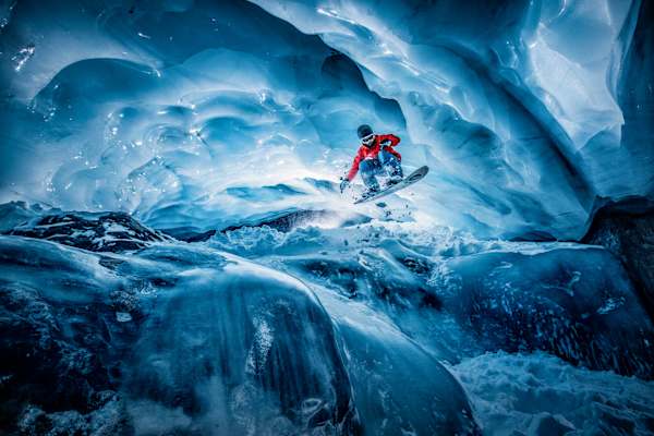 Snowboarder in einem Gletschertunnel hoch oben am Pitztaler Gletscher