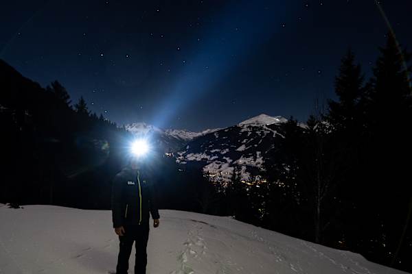 Mann mit Stirnlampe in der Nacht