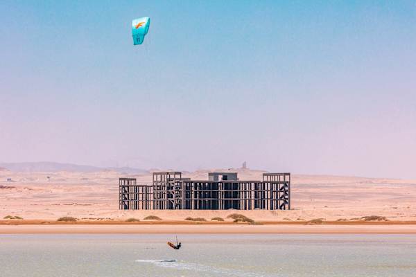 Kitesurfer in Ägypten vor einem unfertigen Gebäude.