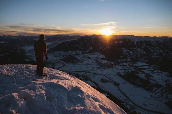 Stefan Pointner genießt die ersten Sonnenstrahlen am Gipfel des Grimming. Das Ennstal weiter unten liegt noch im Dornröschenschlaf.