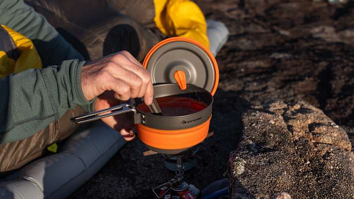 Outdoor-Kochen mit dem Sea to Summit Frontier Kochset – Camper bereitet Mahlzeit im leichten, faltbaren Topf auf Gaskocher zu