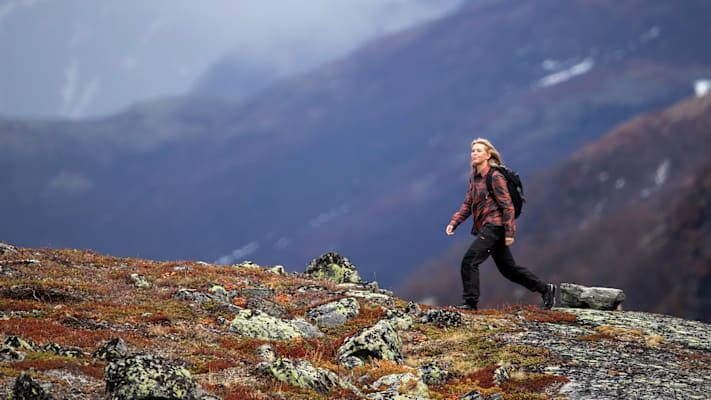 Eine Frau mit Herbst-Sportkleidung in der Natur.