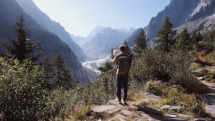 Der Mann sieht in Richtung der Berge im Gebirge.