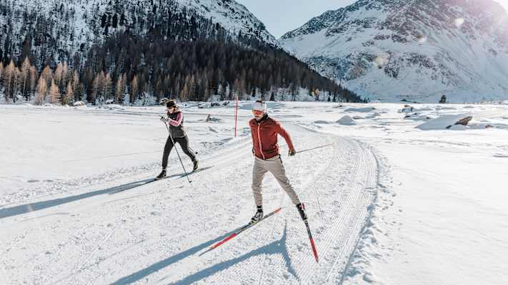 Auf perfekt gespurten Loipen gleitet man durch verschneite Wälder und weite Täler.