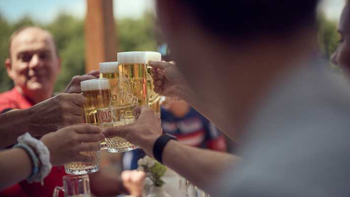 Gruppe an Menschen stößt mit einem Bier an