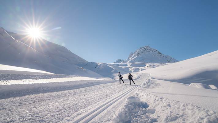 Eine Langläuferin und ein Langläufer ziehen ihre Spuren in Ischgl.