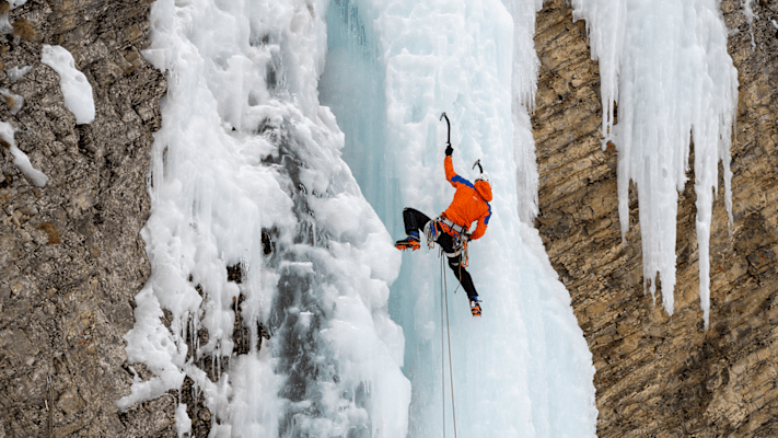 Ein Eiskletterer klettert eine Eiswand hoch und trägt dabei die Eiger Extreme Nordwand 6.0 Kollektion von Mammut.