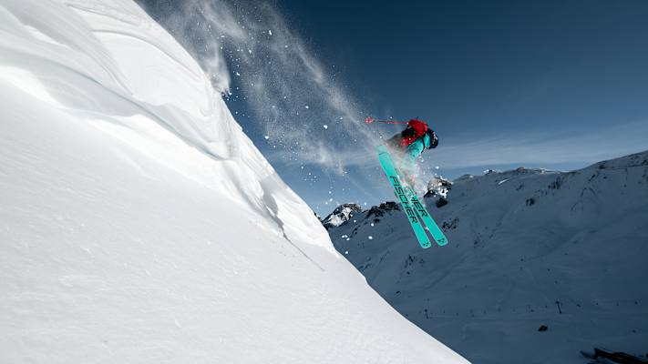 Ein Freerider fährt einen unberührten Hang hinunter.
