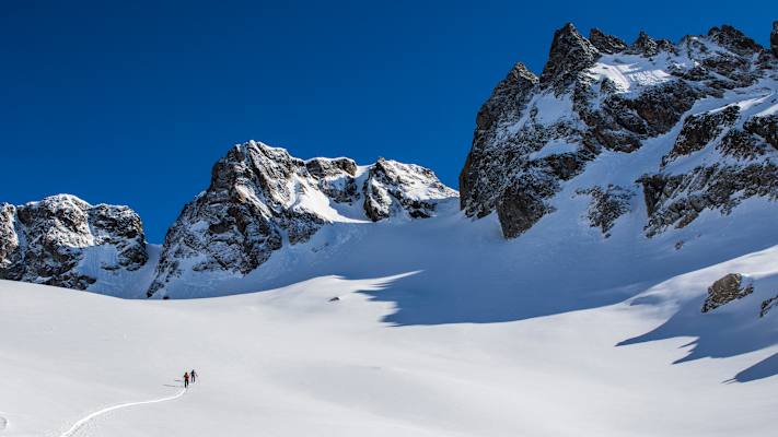 Zwei Skitourengeher gehen eine unberührte Route auf der Urner Haute Route in den Schweizer Alpen.