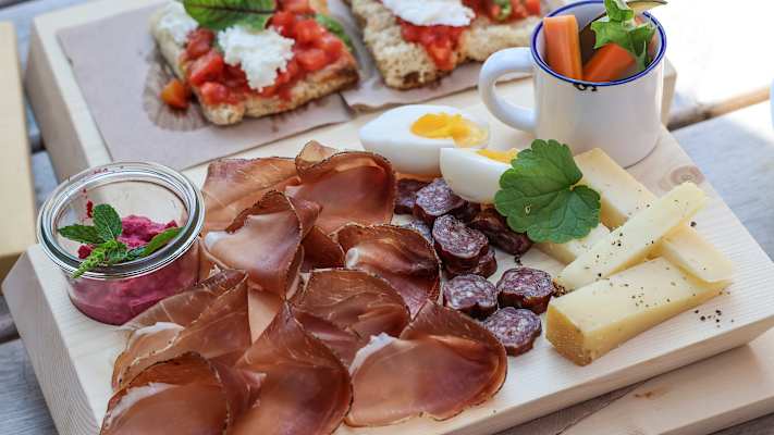 Eine Brettljausn mit Wurst, Käse, Eiern und Gemüse.