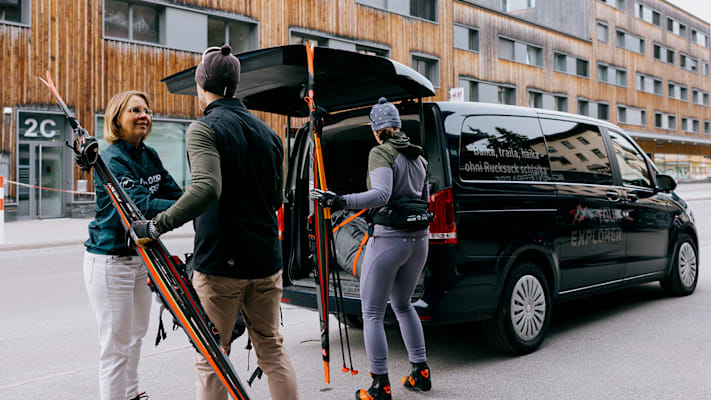 Vor dem Hotel räumen die zwei Sportler den Van ein, um Skilanglaufen zu gehen in der Schweiz.