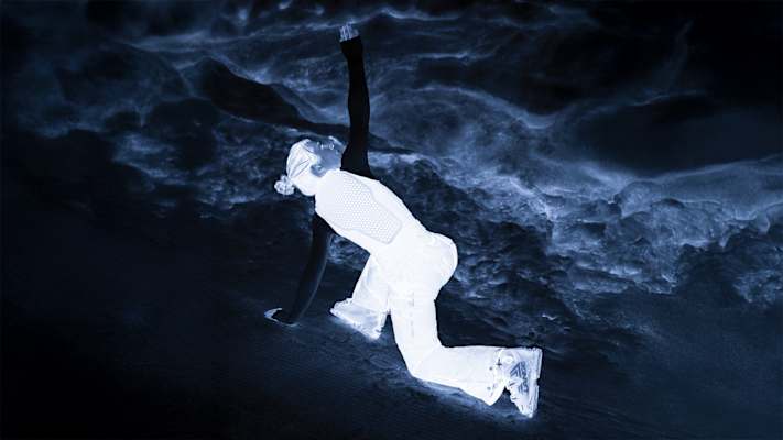 Skifahrer in schützender VPD-Weste von POC, künstlerisch in negativer Farbgebung dargestellt, kniend auf einer verschneiten Piste.