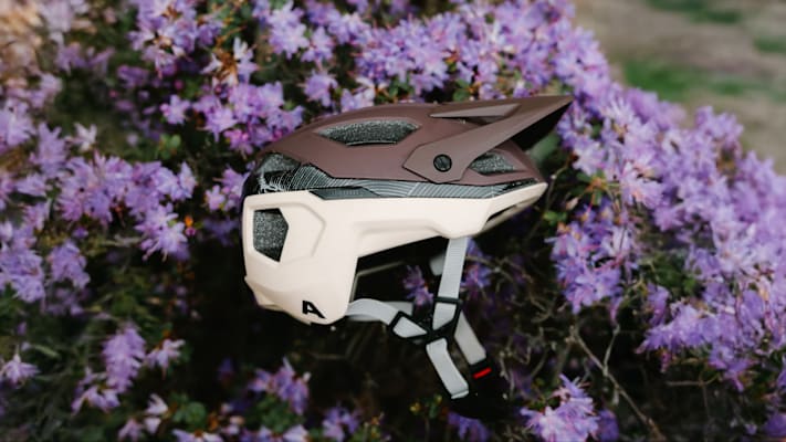 Ein Helm liegt in der Blumenwiese.