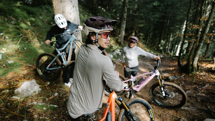 Drei junge Menschen mit Helmen von Alpina Sports auf den Trails mit ihren Rädern.