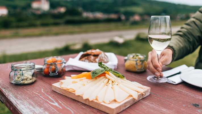 Auf einem Tisch sieht man eine Käseplatte, Aufstriche und frisches Brot