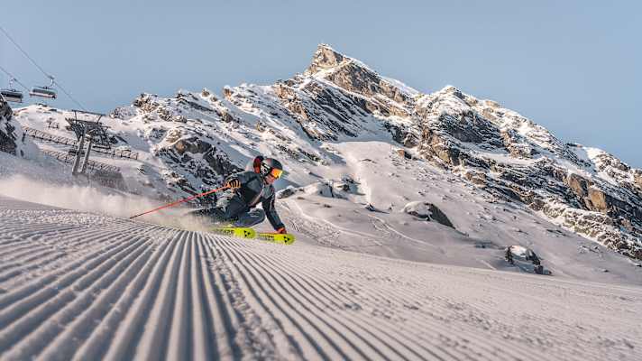 Ein Skifahrer fährt eine perfekt präparierte Piste hinunter.