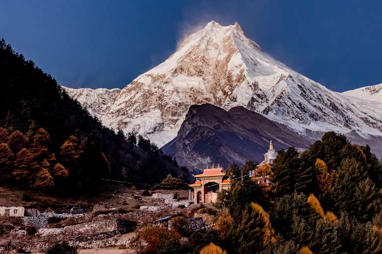 Ein Kloster und dahinter der mächtige Manaslu im Licht des Morgens