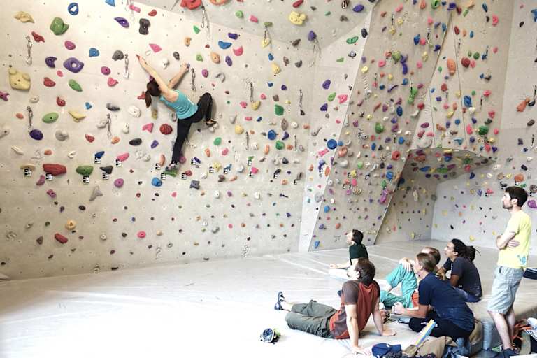 Eine Sportkletterlehrerin ist für Ausbildung und Training beim Bouldern und Vorstiegsklettern qualifiziert. 