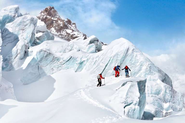 Die Gruppe vor einem imposanten Gletscherabbruch bei strahlend blauen Himmel.