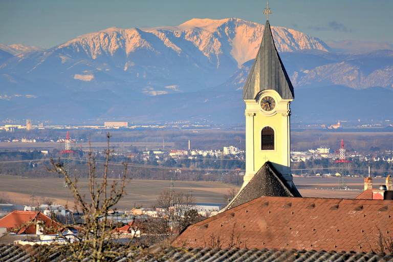 Die Pfarrkirche Hornstein am Westhang des Leithagebirges mit Blick zum Schneeberg