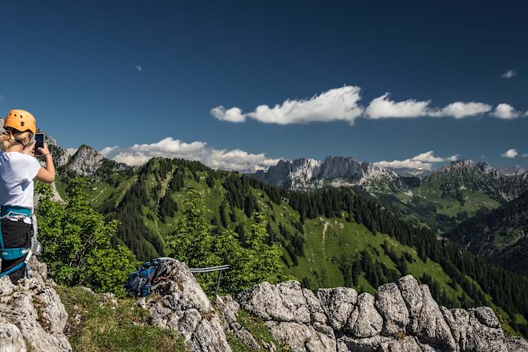 Eine Klettersteiggeherin macht am Ende der Via Ferrata Charmey im Kanton Freiburg ein Foto mit ihrem Handy.