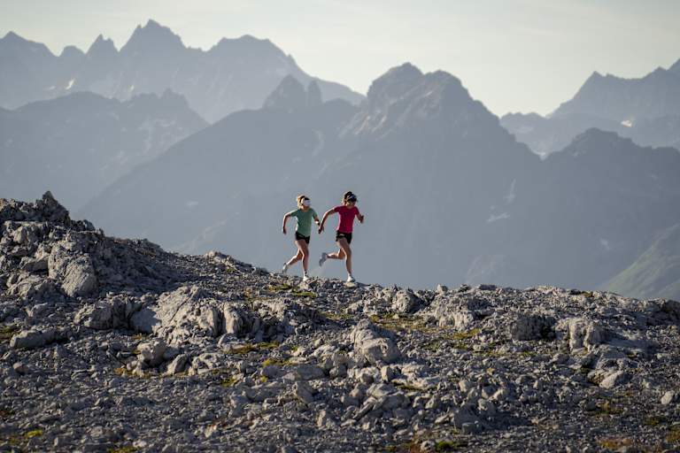 Zwei Frauen laufen über einen Berg