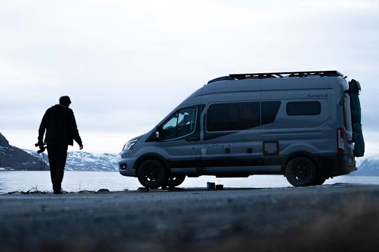 Ein Sunlight Camper steht vor einem See.