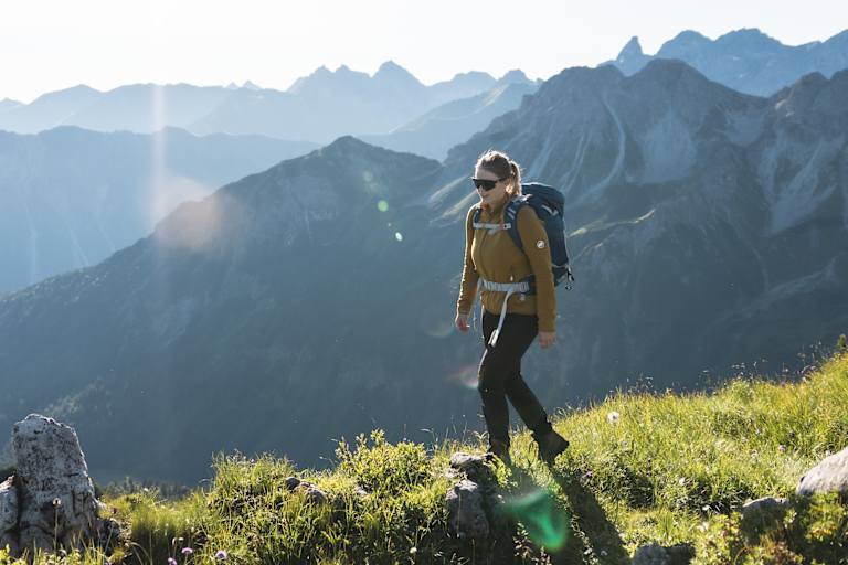 Eine Wanderin vor einer Bergkulisse.