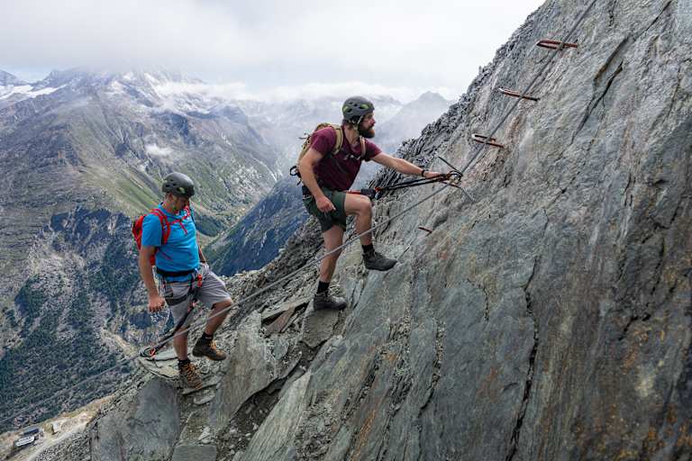Zwei Kletterer steigen auf den Mittaghorn Klettersteig im Saastal.
