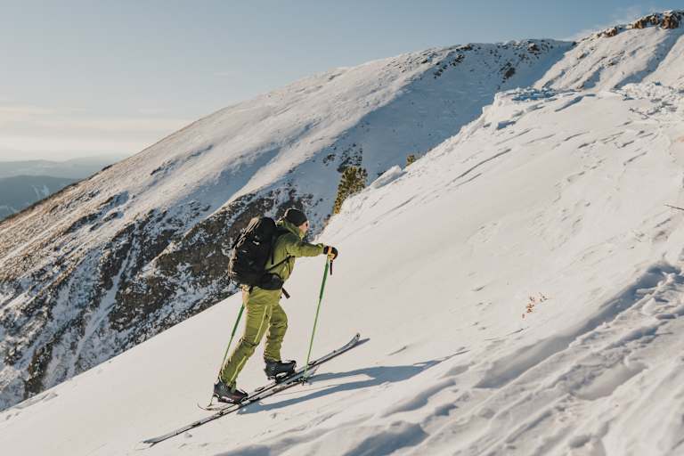 Immer am Boden bleiben: Wer die Ski bei jedem Schritt anhebt, verschenkt unnötig Energie. Viel effektiver: Ein gleichmäßiges Schlurfen. Und die g`schmackigen Salami Sticks von Loidl – sie liefern wertvolle Proteine und geben im Aufstieg Kraft.