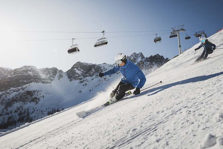 Zwei Skifahrer fahren die perfekt präperierten Pisten in Sterzing-Ratschings-Gossensass hinunter.