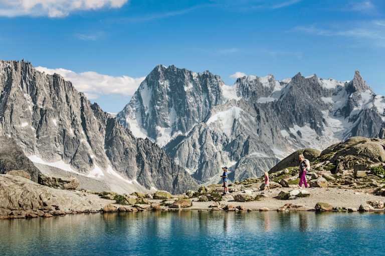 Eine Familie wandert vor einer atemberaubenden Berglandschaft