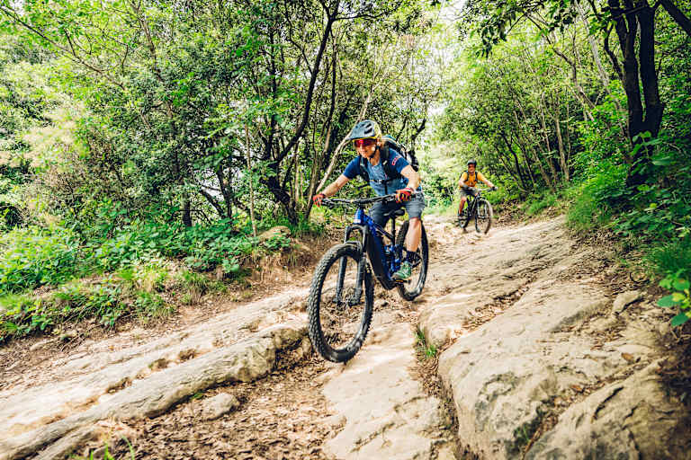 Frau fährt auf einem Mountainbike bergab