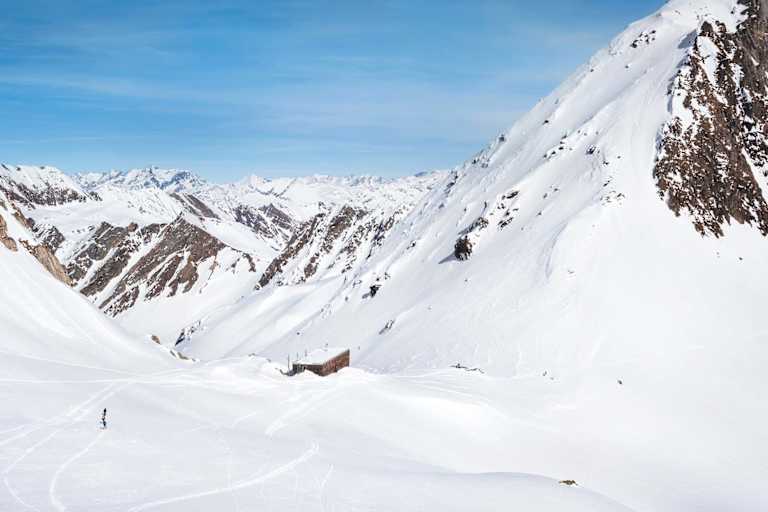 Die moderne Hütte schmiegt sich in die alpine Landschaft.