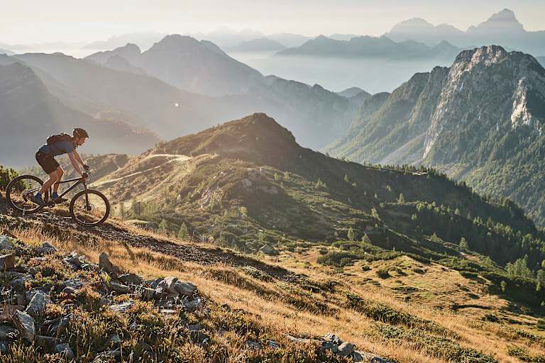 Abwärts in sanftem Licht: Mountainbiken mit Panoramablick.