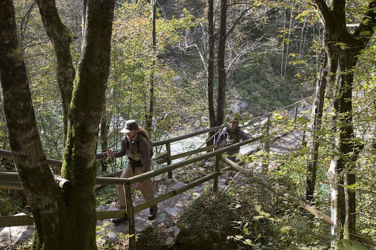 Fliegenfischer wandern durch den Bach
