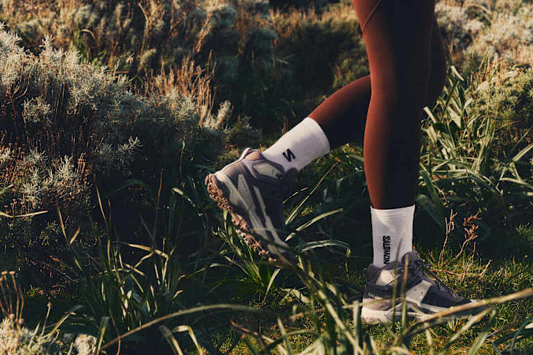 füße in salomon ausrüstung im gras beim wandern