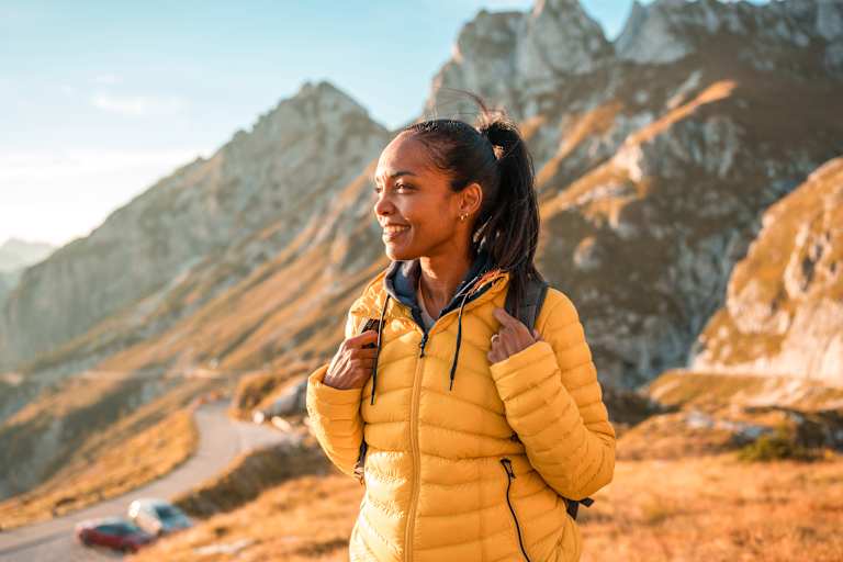 frau in den bergen beim wandern genießt den ausblick im herbst