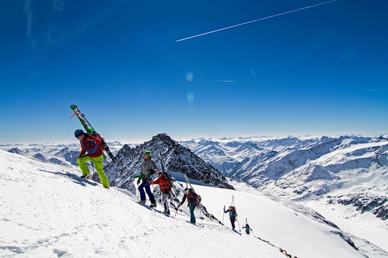 Die Alpinisten stapfen den Berg hinauf.