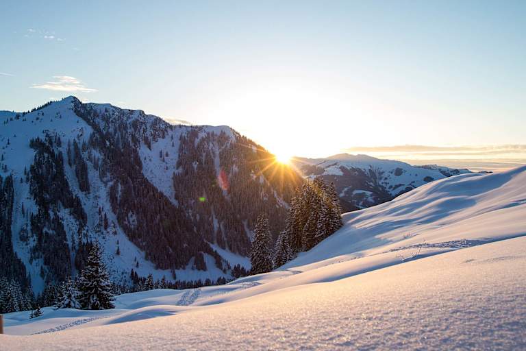 Die Abendsonne verschwindet hinter den schneebedeckten Gipfeln.