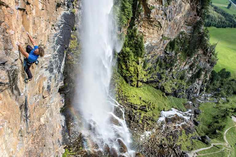 Kletterer klettert gesichert eine Bergwand hoch